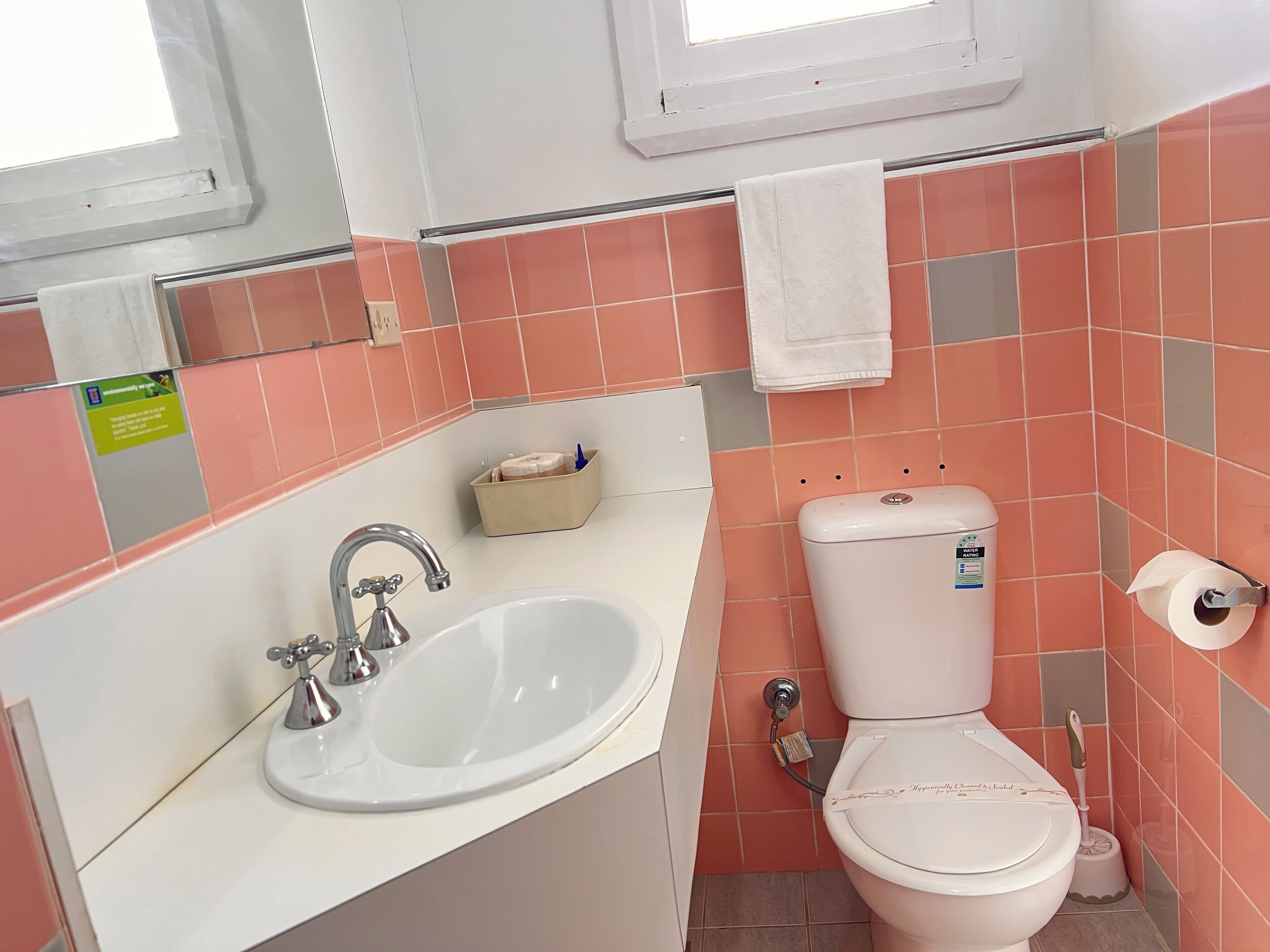 A bathroom with a sink, toilet, and a window.