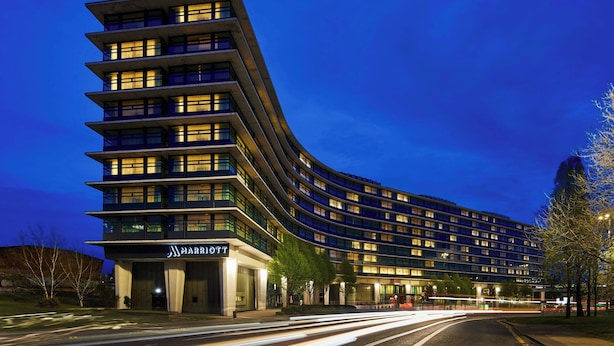 A modern hotel with a curved facade, multiple floors, and illuminated windows. - Manchester Marriott Hotel Piccadilly (Manchester)