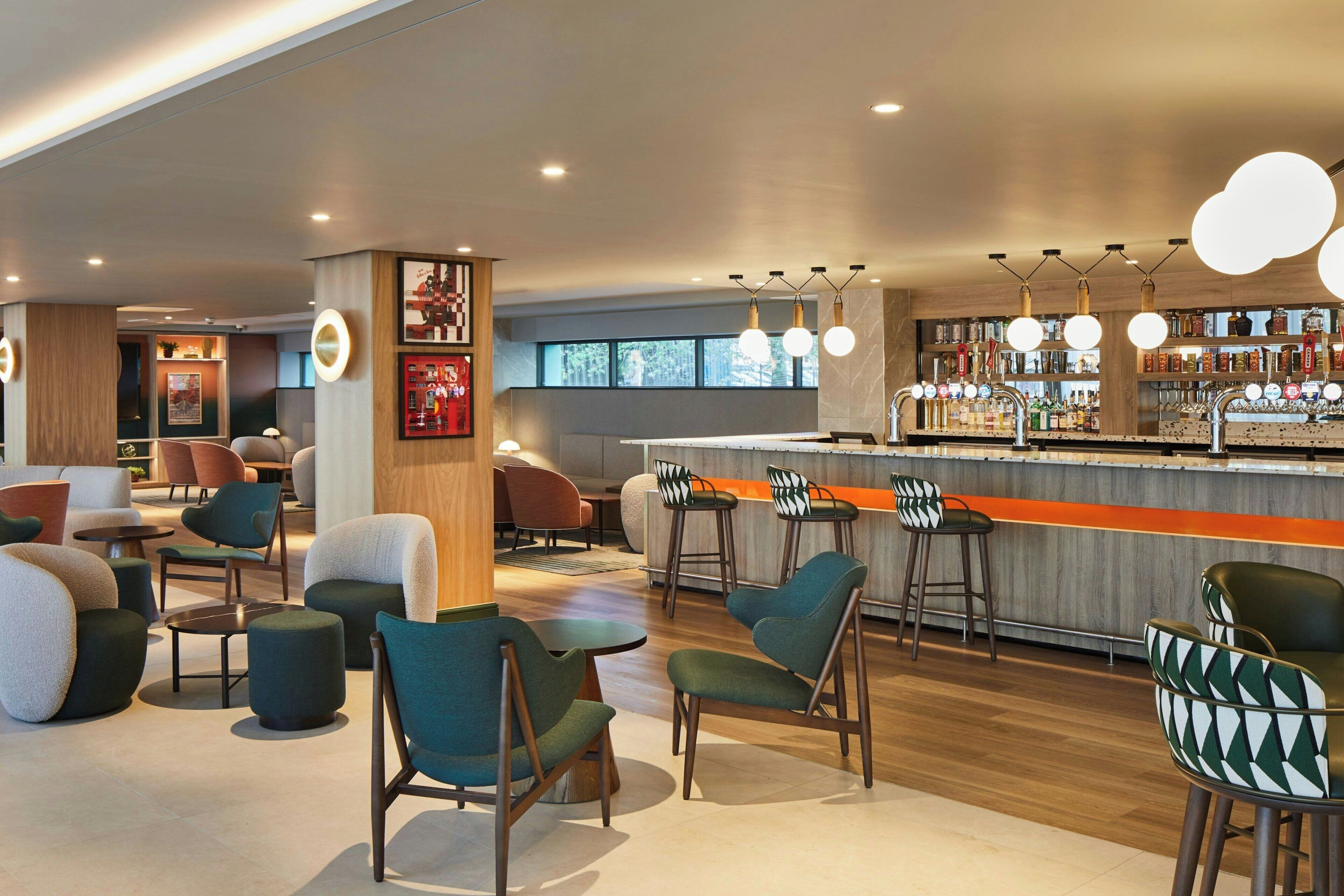 Un área de bar moderna con asientos y una barra.