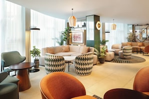 A modern lounge area with a sofa, chairs, and a coffee table.