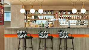 A bar area with three stools, a variety of bottles, and a bar counter. - Manchester Marriott Hotel Piccadilly (Manchester)