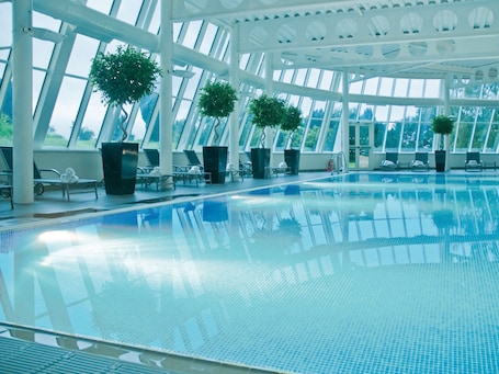 Una piscina techada, sillones reclinables de piscina