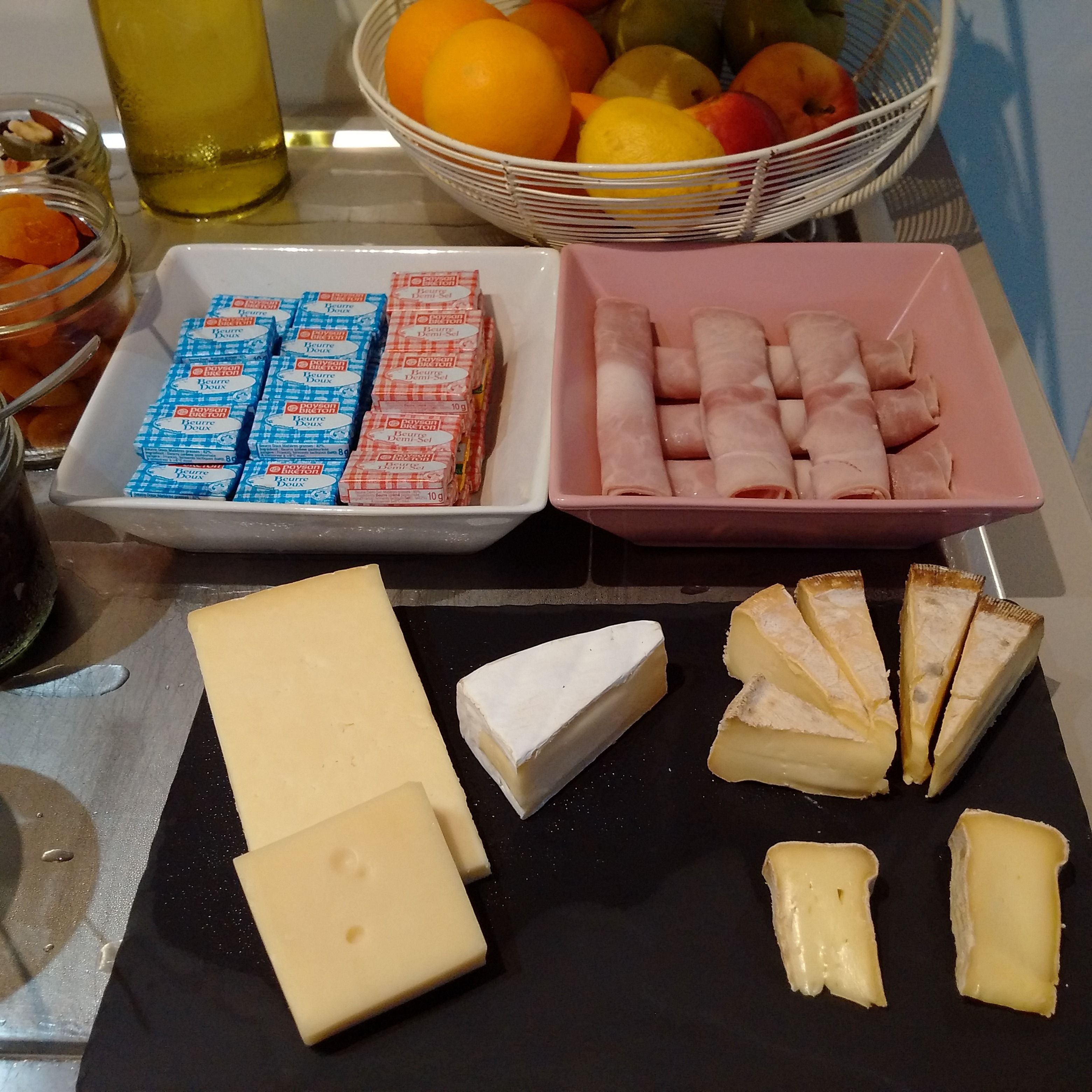 Une table garnie de divers aliments, notamment du fromage, de la viande et des produits emballés.
