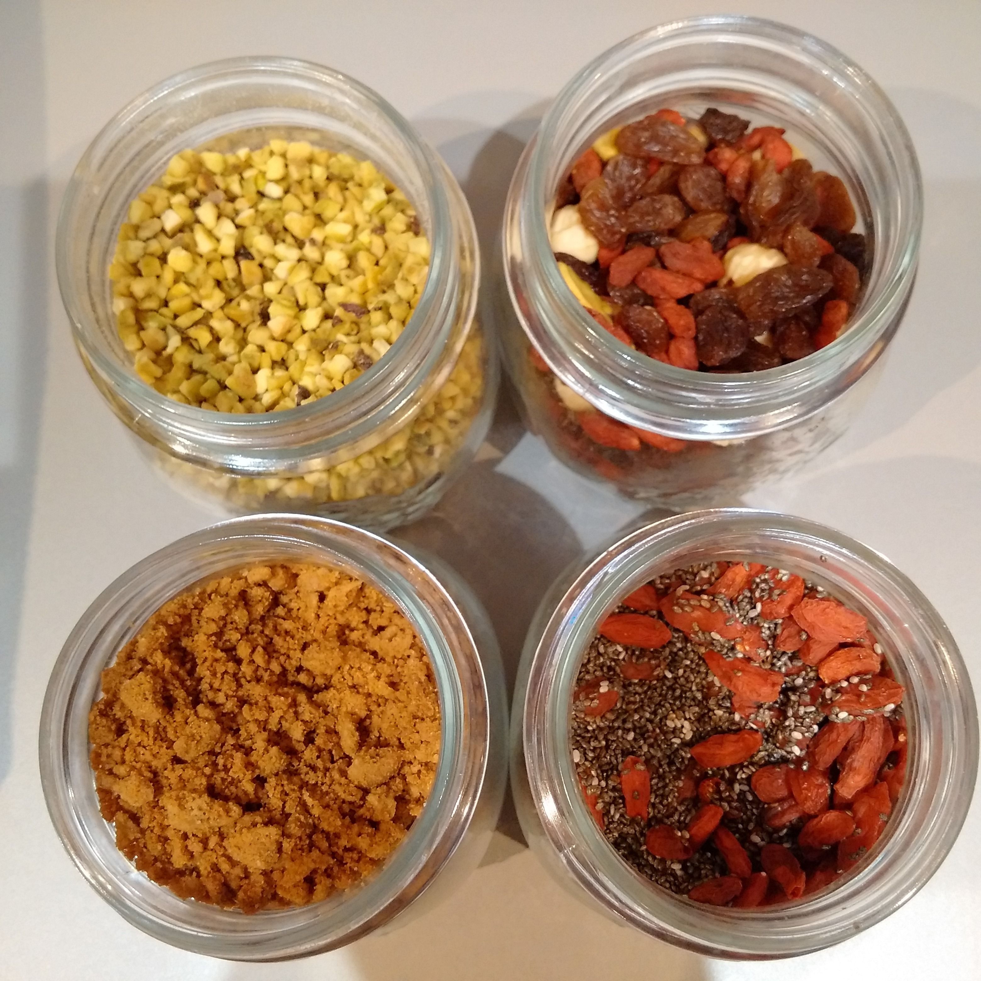 Four glass jars containing different food items.
