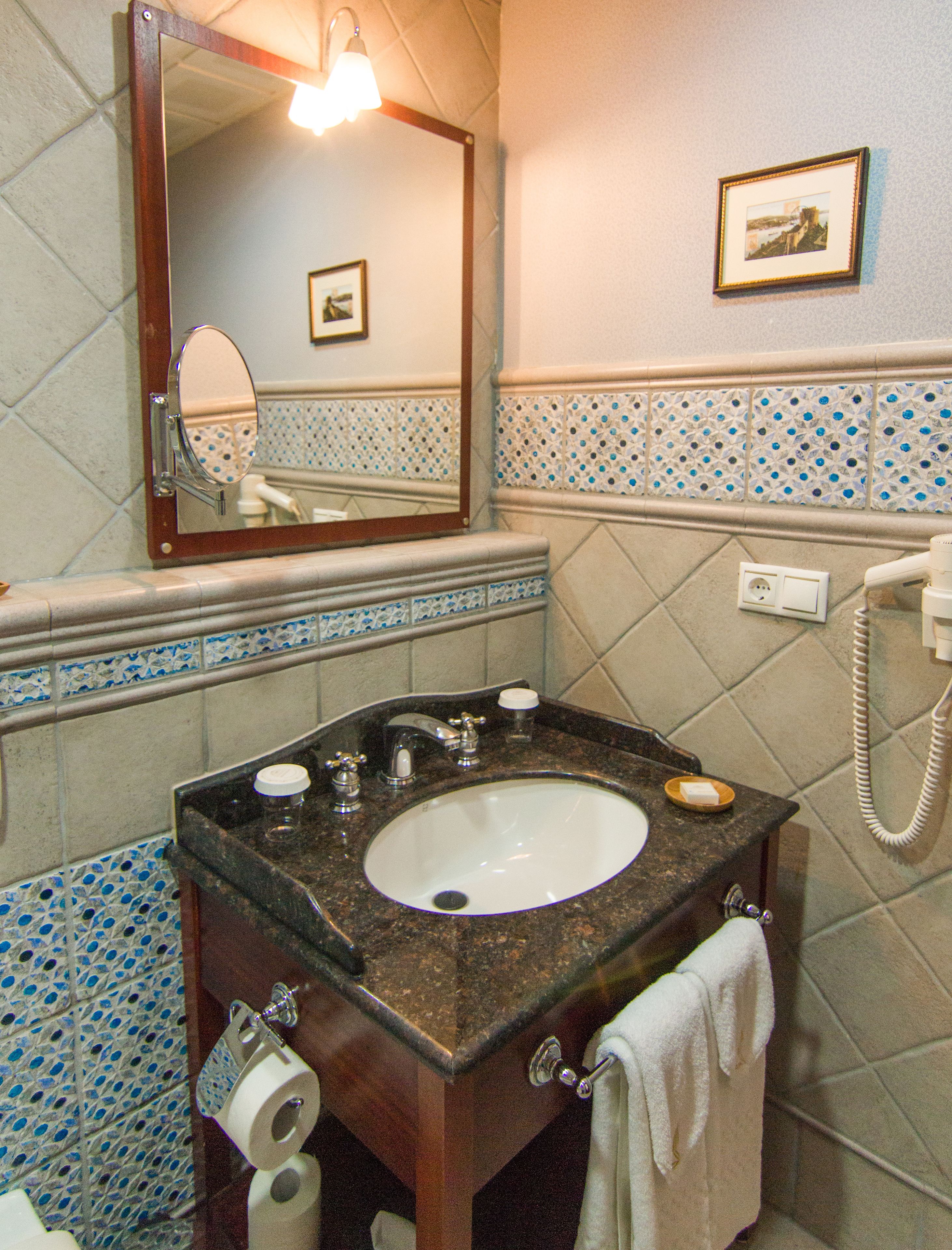 Un bagno con lavandino, specchio e telefono.