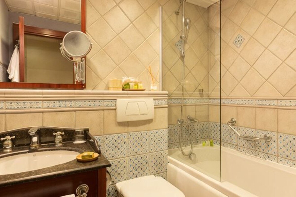 Un baño con lavamanos, espejo y ducha.