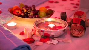 Una mesa con una vela, un frutero y un adorno decorativo.