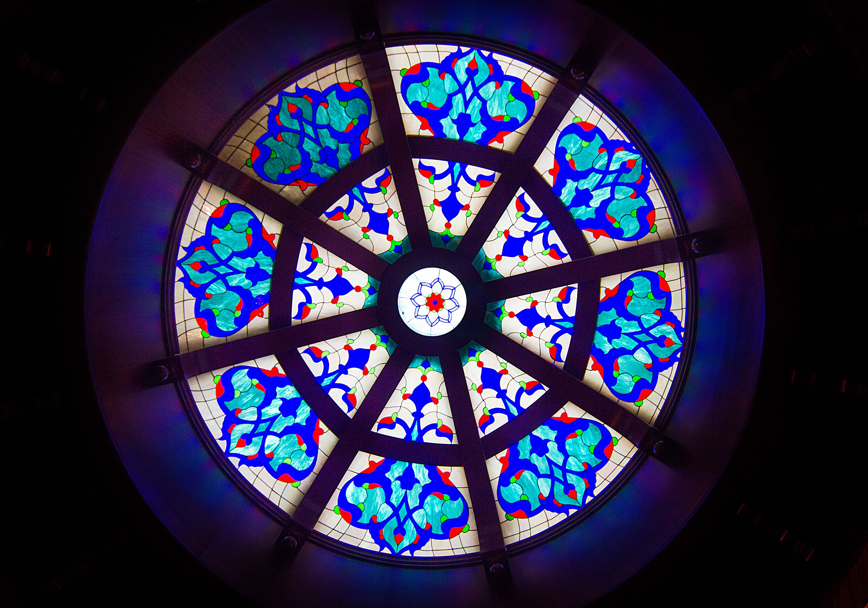 Una ventana circular de vitral con un diseño floral.
