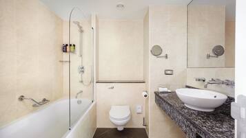 A modern bathroom with a bathtub, toilet, and sink.