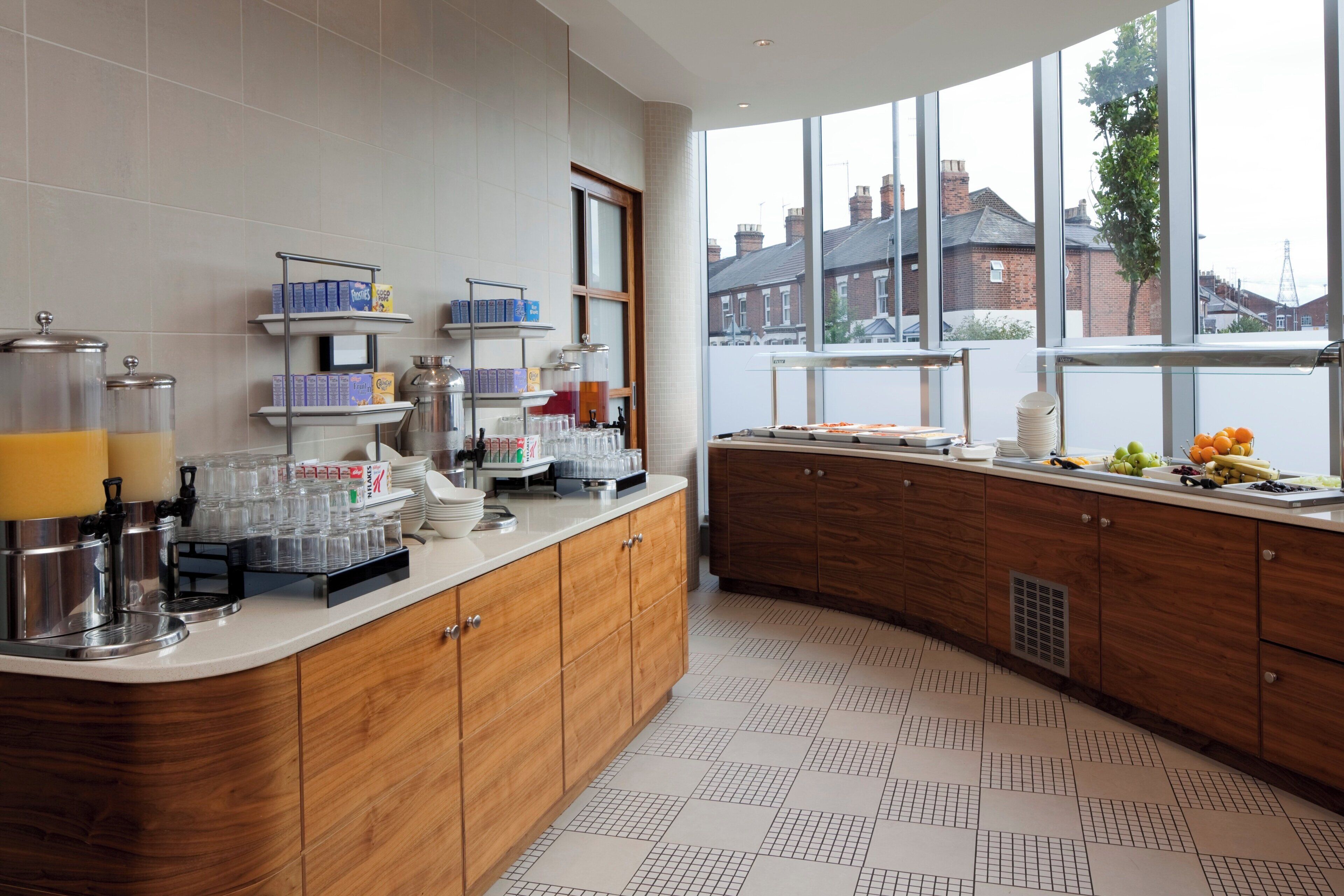 A modern kitchen with a breakfast bar, breakfast items, and a view of the city.
