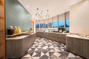 Una cocina moderna con piso de diseño geométrico, armarios de madera e iluminación colgante.