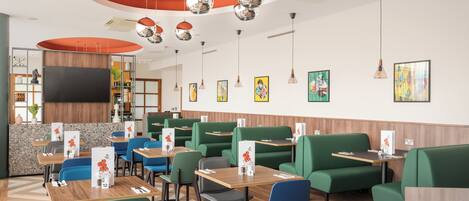 A restaurant with booths and tables, a TV screen, and various wall decorations.