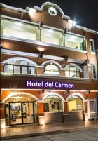Un edificio de varios pisos con un letrero que dice 'Hotel del Carmen'.