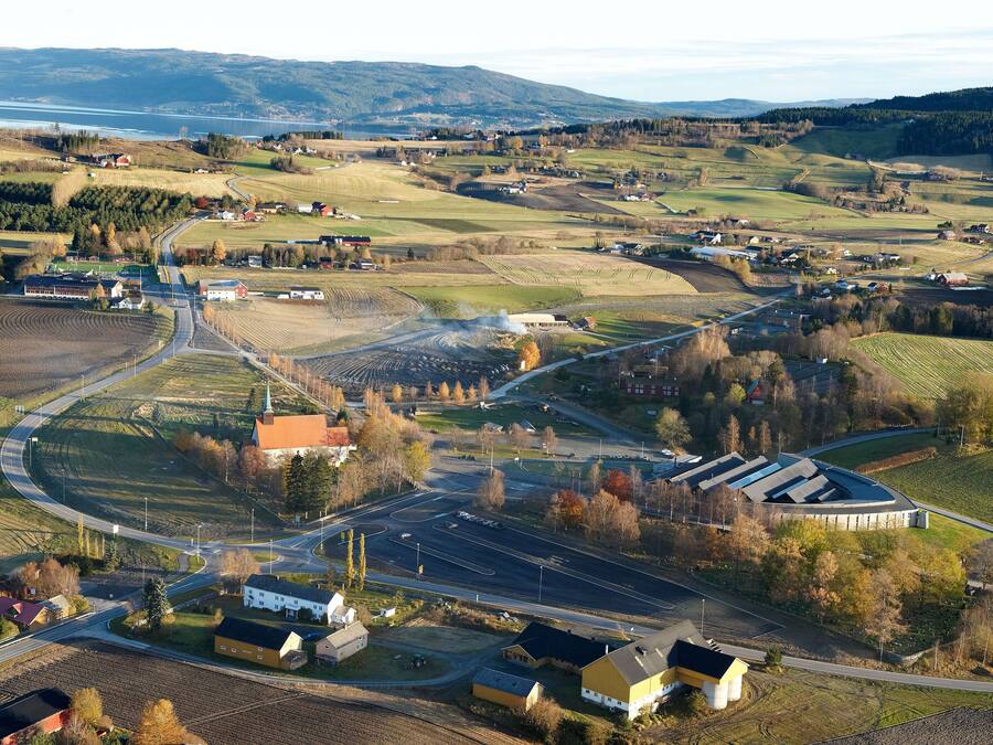 Vista aérea de una zona rural con una glorieta, campos y edificios dispersos.