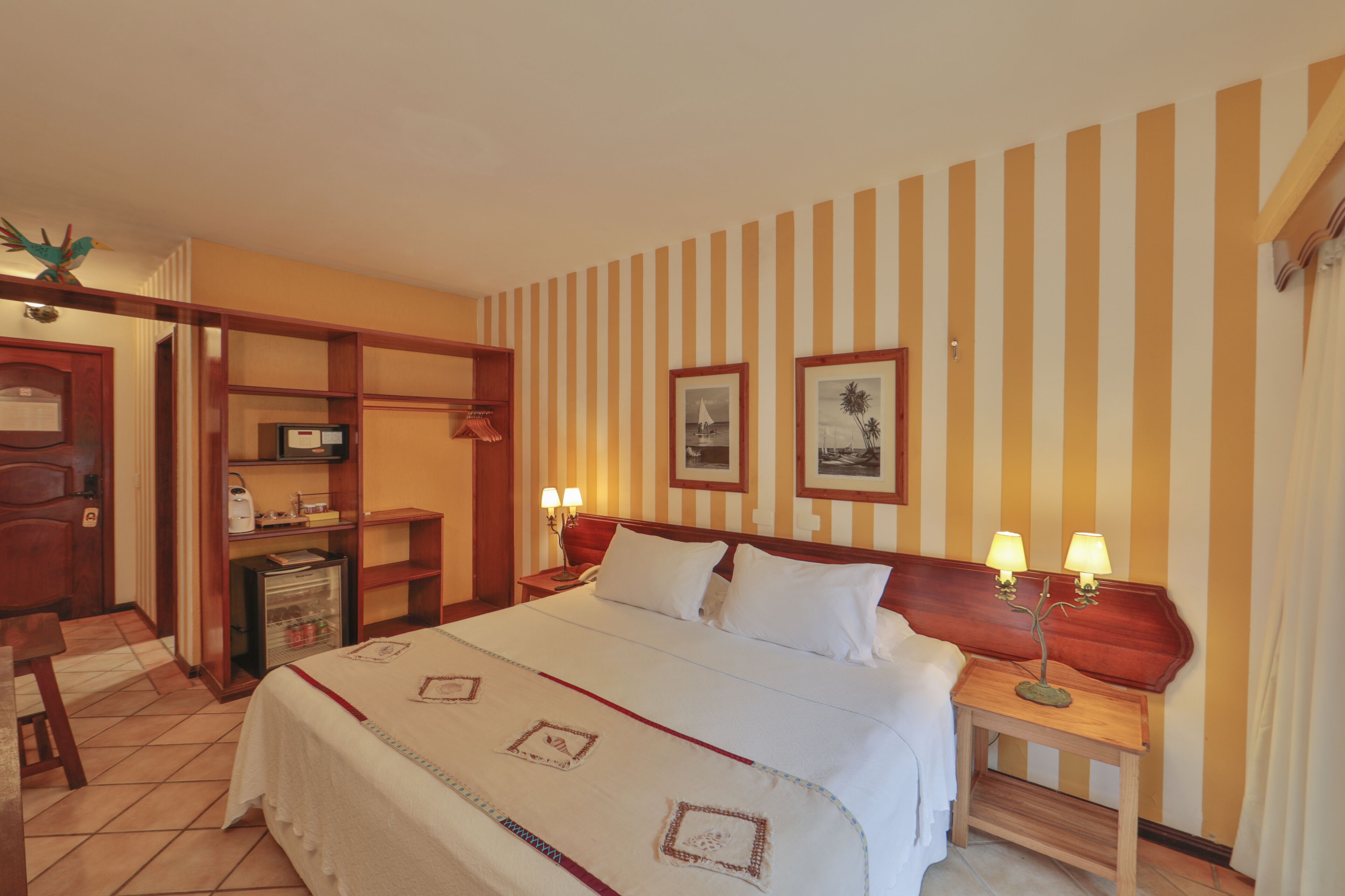 Una habitación de hotel con una cama, mesitas de noche, un escritorio y una silla.