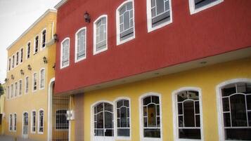 A row of colorful buildings with multiple windows and doors, including a visible hotel sign.