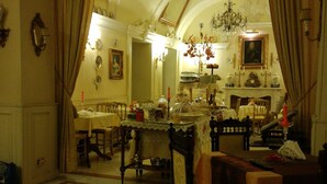 A dining area with a chandelier, a fireplace, and a view into the kitchen. - Ai Savoia B&B - Guest House  (Turin)