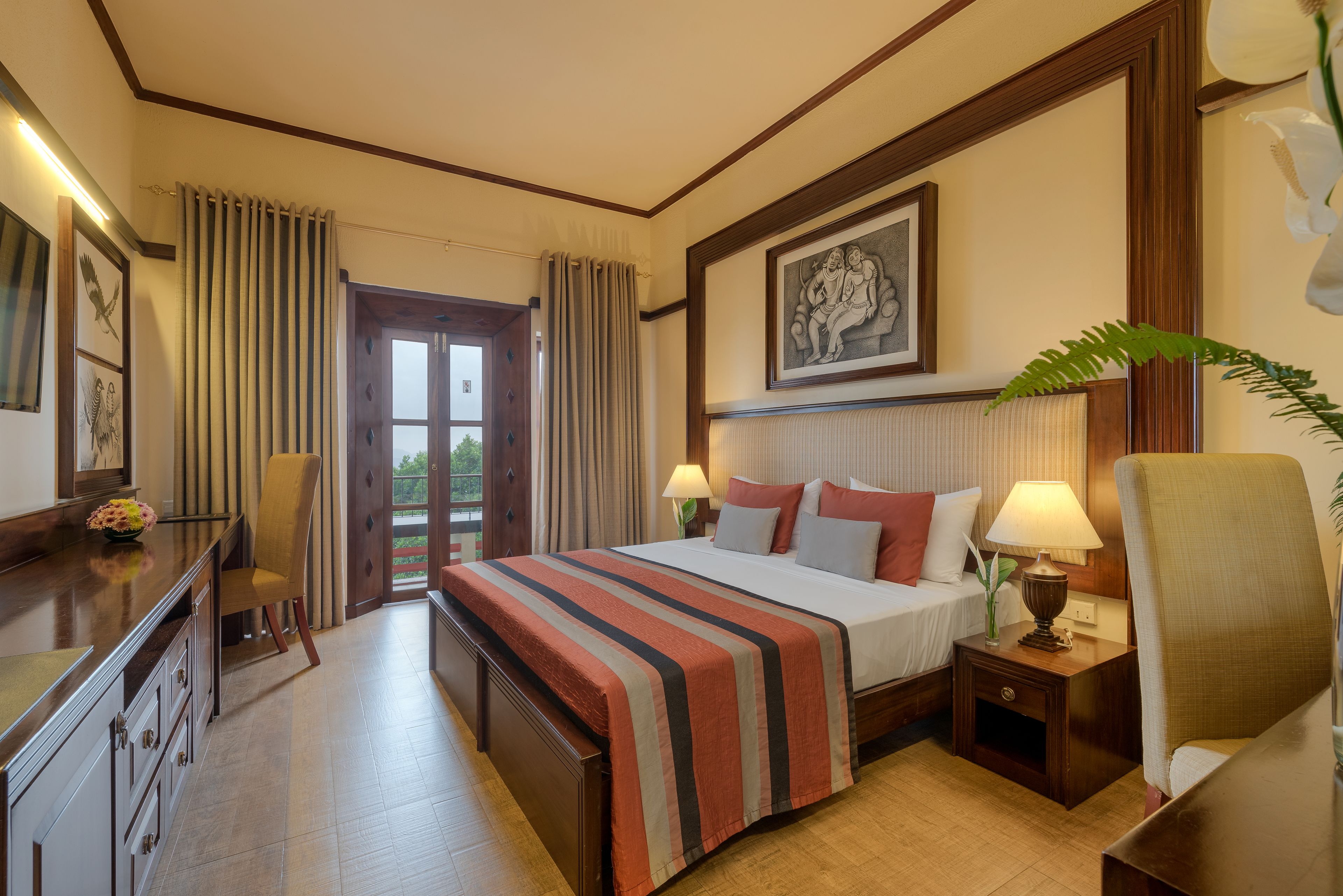 A hotel room with a bed, bedside tables, a desk, and a chair.