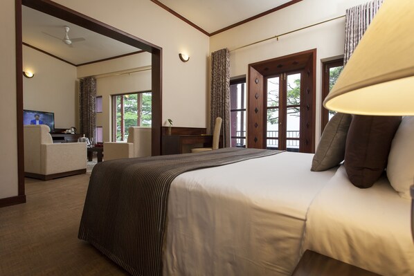 A hotel room with a large bed, a desk, a chair, and a television.
