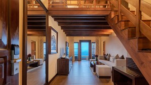 A spacious hallway with a wooden staircase, a seating area with sofas, and a view to the outside. - Amaya Hills Kandy (Kandy)