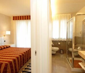 A hotel room with a bed, a shower, and a toilet. - Hotel Dante Residence (Mantua)
