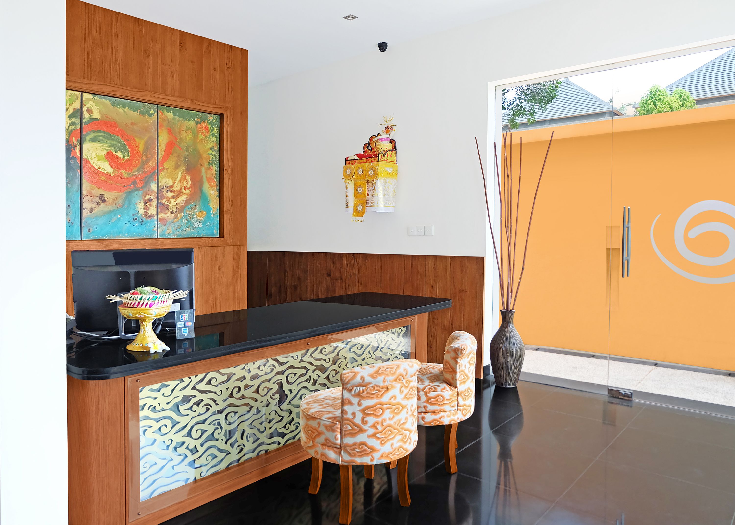 Un interior moderno con una encimera negra, paneles de pared con diseño, un jarrón decorativo y un mueble de madera.