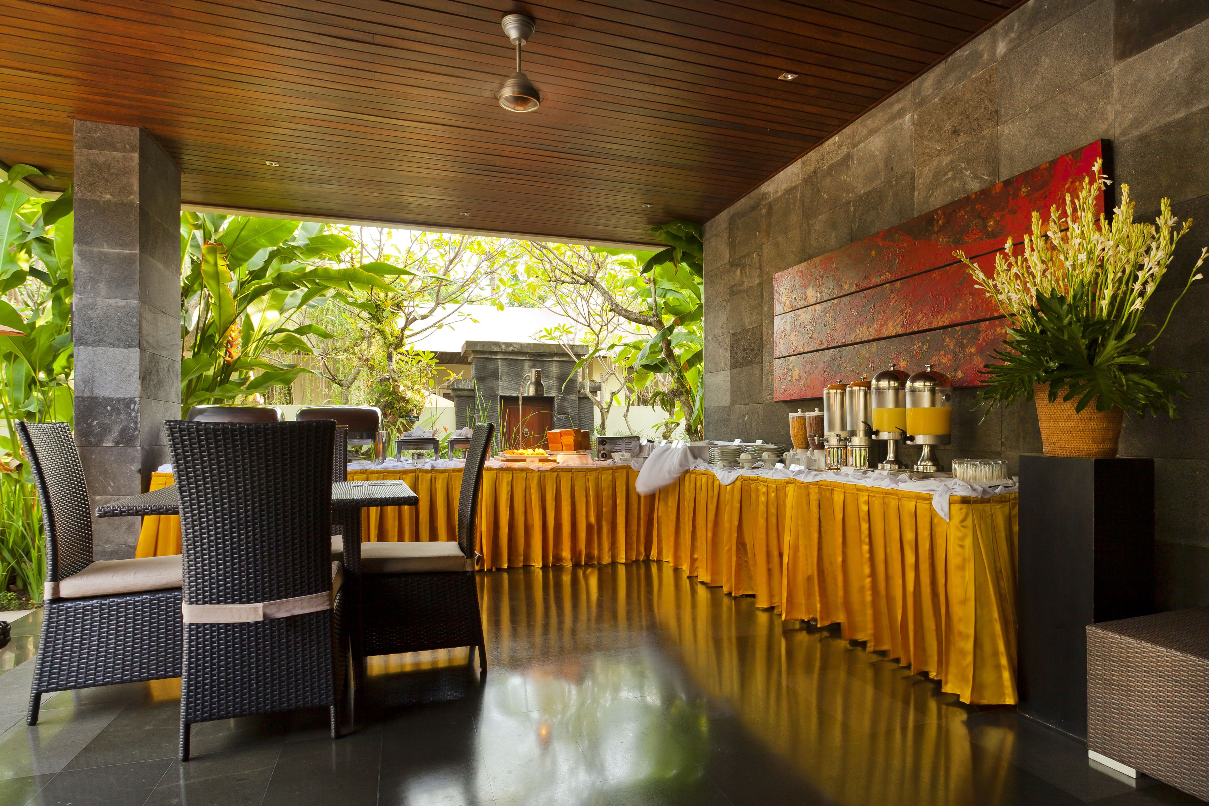 Un espace de restauration abrité, avec une longue table, des chaises et un buffet.