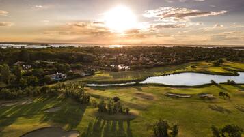 Enjoy golfing amidst a well-maintained landscape with sand bunkers and a pond.