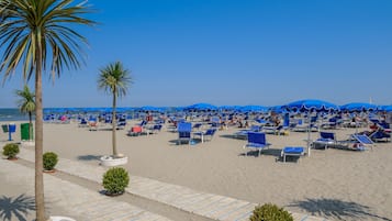 On the beach, white sand, sun-loungers, beach umbrellas