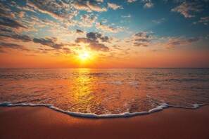 Una playa con olas al atardecer.