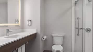 A modern bathroom with a sink, toilet, and glass shower enclosure.