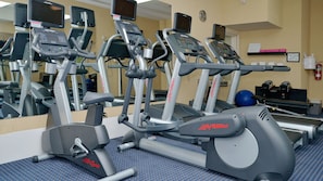 A gym with multiple treadmills and elliptical machines, a blue exercise ball, and a water dispenser. - Holiday Inn Express Hotel & Suites Hinton by IHG (Hinton)