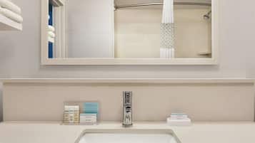 A bathroom with a white sink, a mirror, and a shower curtain.