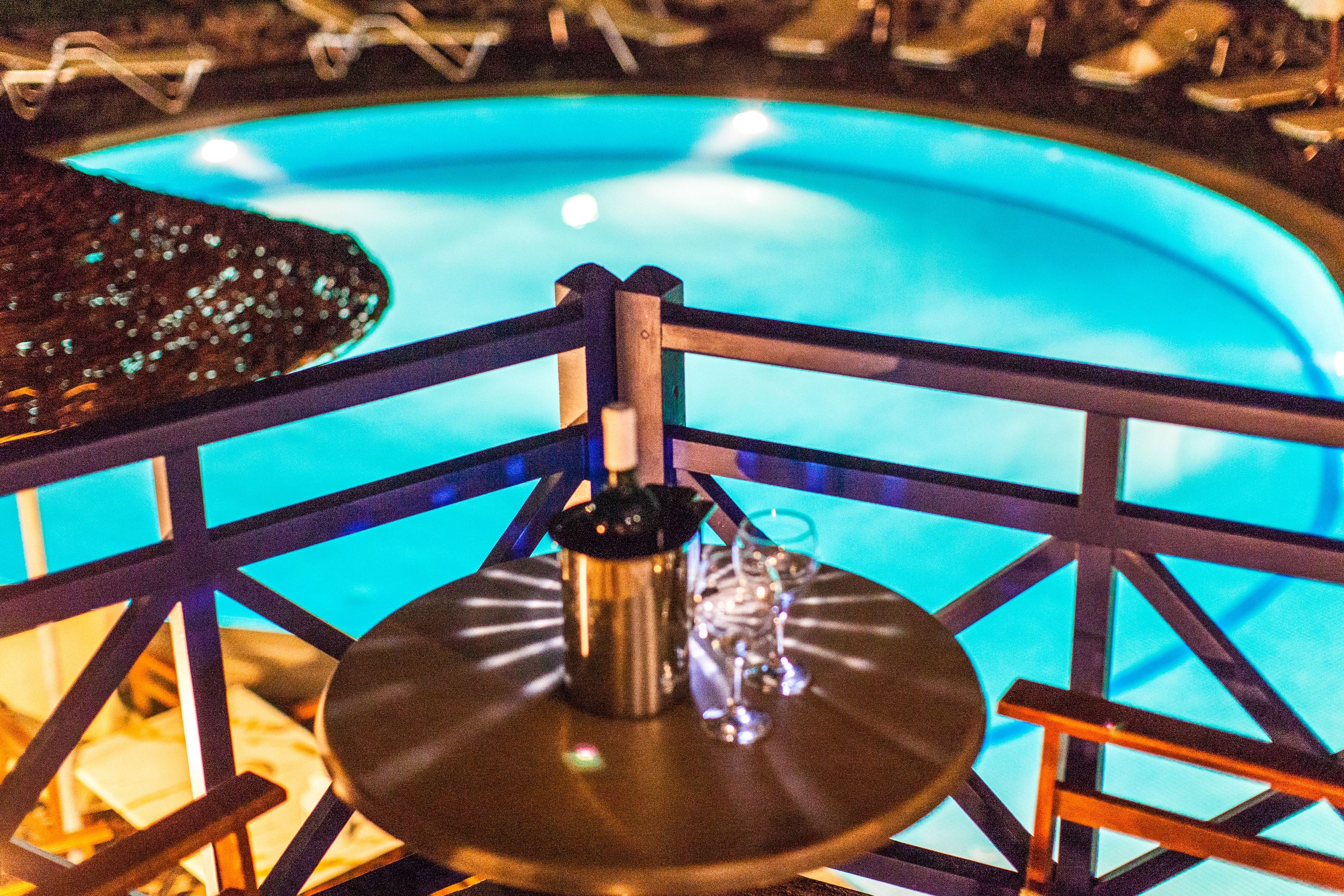Una piscina con barandilla metálica y un jacuzzi.