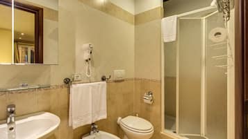 A bathroom with two sinks, a toilet, and a glass-enclosed shower.