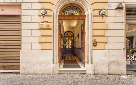 An entrance with a tiled floor leading to a hallway, flanked by two doors with numbers 12 and 13.
