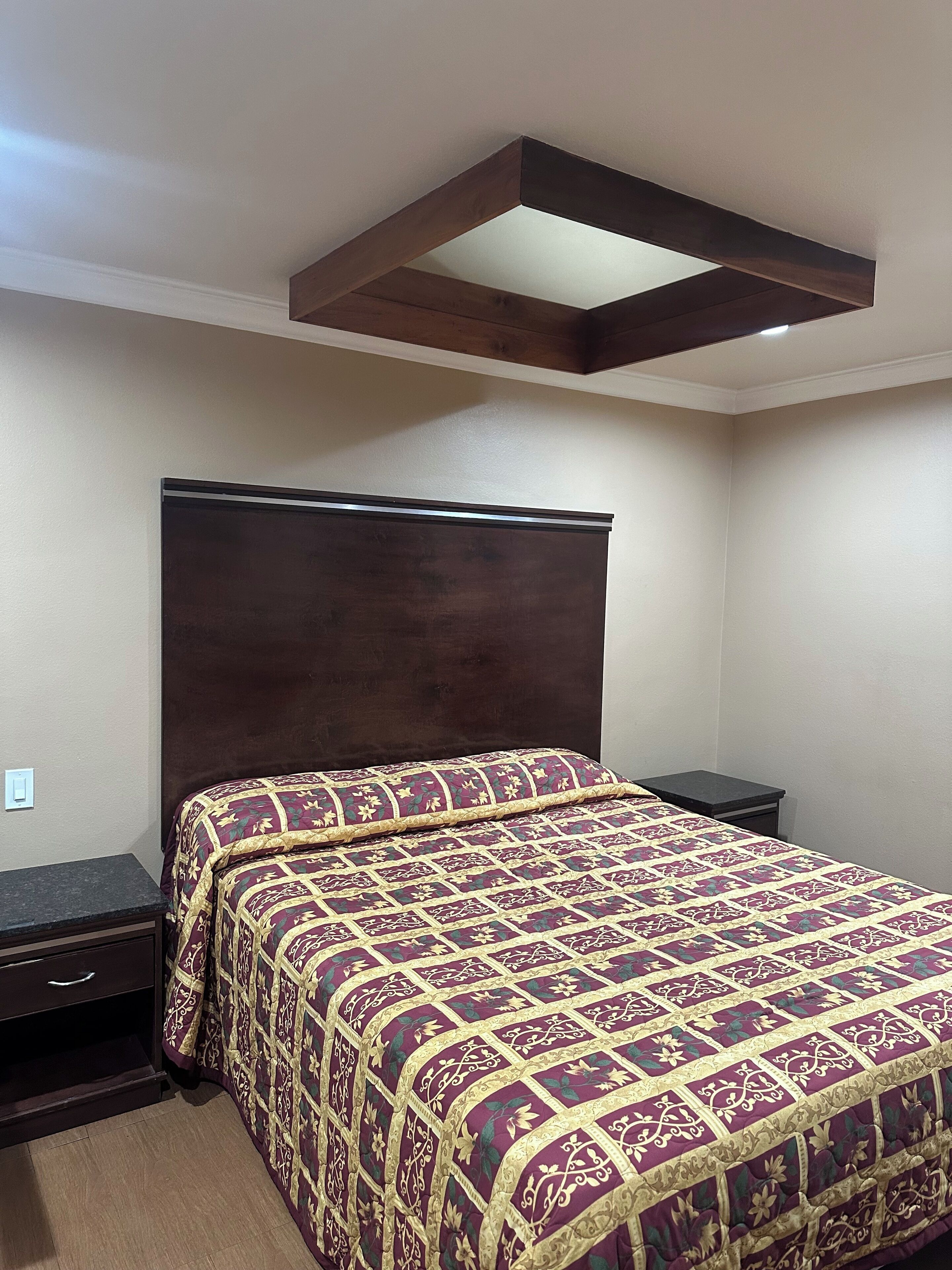 A bedroom with a large bed, a nightstand, and a built-in headboard.