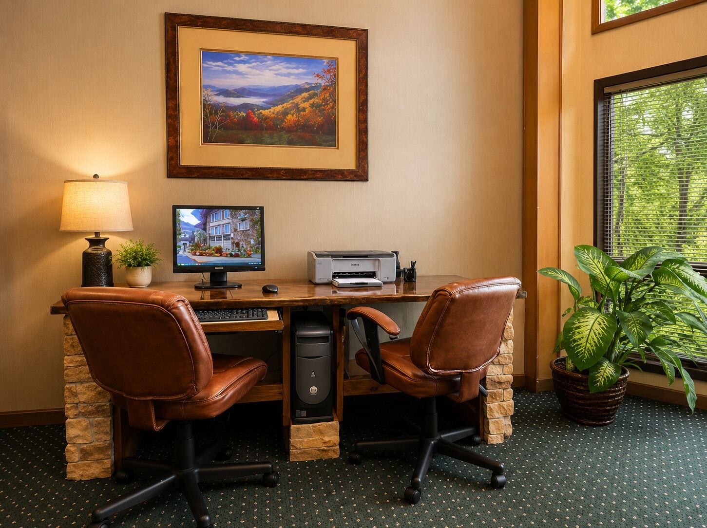 Une chambre d’hôtel équipée d’un bureau, de deux fauteuils en cuir, d’un ordinateur, d’une imprimante, d’une lampe, d’un tableau encadré et d’une plante en pot.