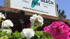 Señal del Leucadia Beach Inn, con logotipo de palmera, que indica un complejo turístico frente al mar.