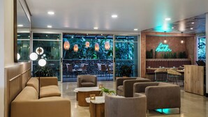 Ein stilvoller Lounge-Bereich mit Sofas, Tischen und hängenden Pendelleuchten.