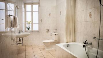 Un bagno moderno con vasca, servizi igienici e lavandino.