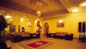 A spacious lobby with a red carpet, multiple sofas, and a chandelier.