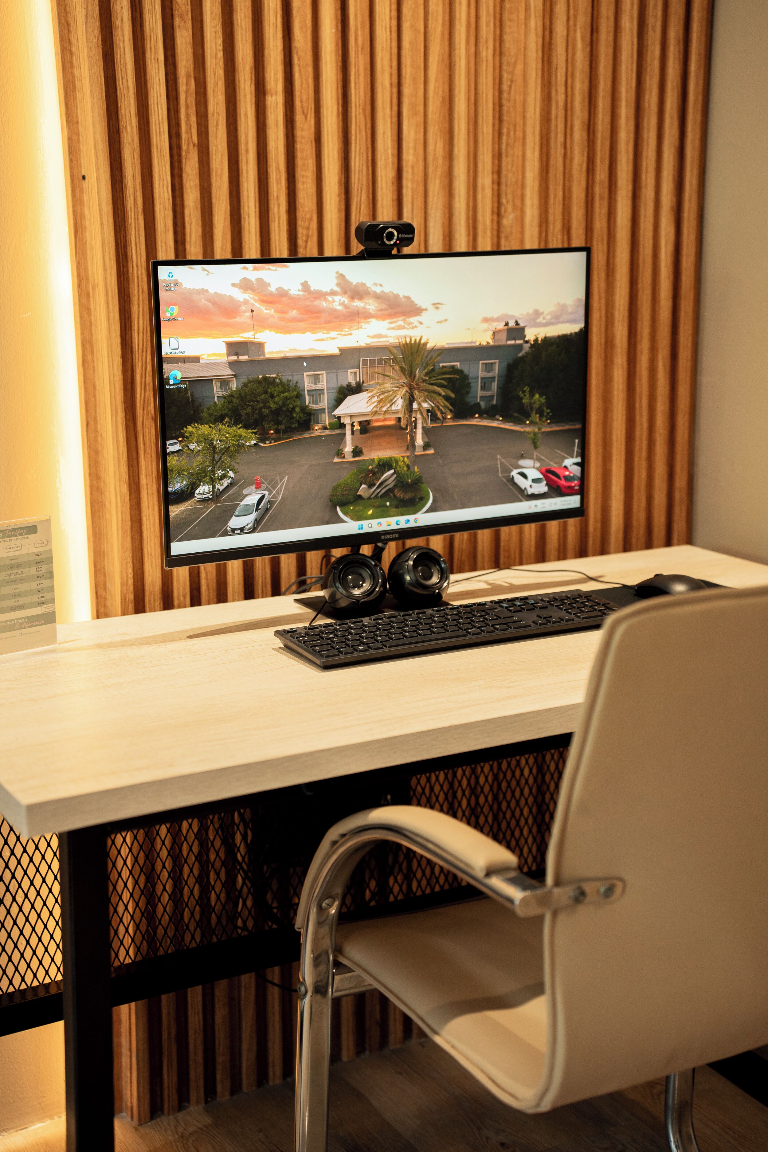 A computer setup with a monitor displaying a street view, a keyboard, and a mouse on a desk.