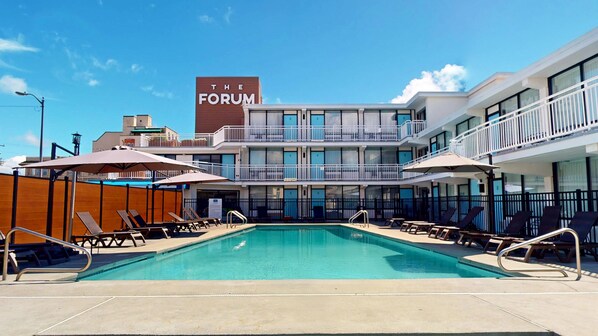 A hotel with a pool, sun loungers, and a sign reading "The Forum". - The Forum (Ocean City)