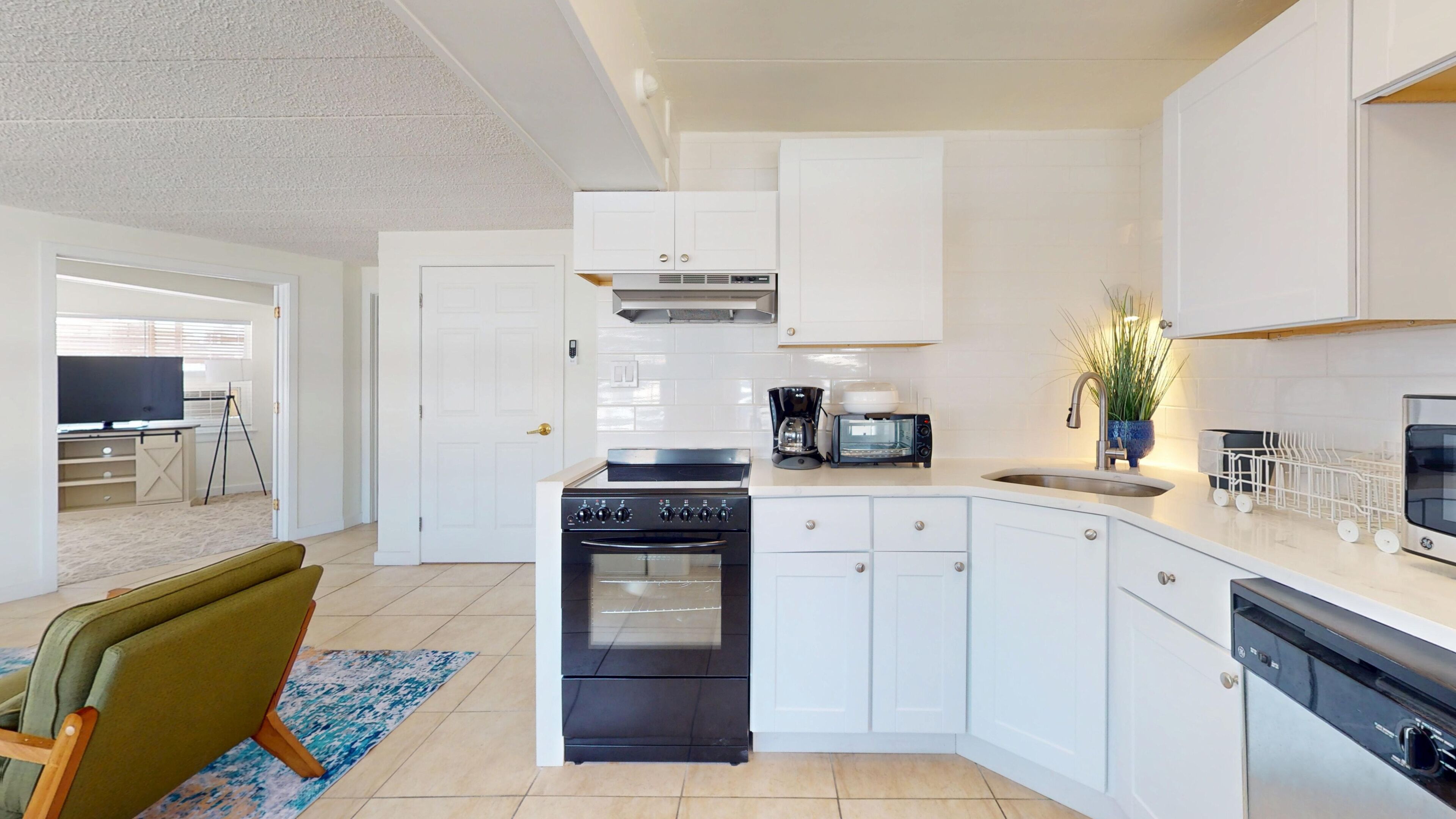 A modern kitchen with white cabinets, a stove, a microwave, and a dishwasher.