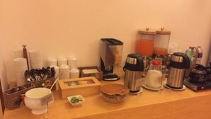 Una barra de desayuno con diferentes electrodomésticos, utensilios y recipientes de cocina.