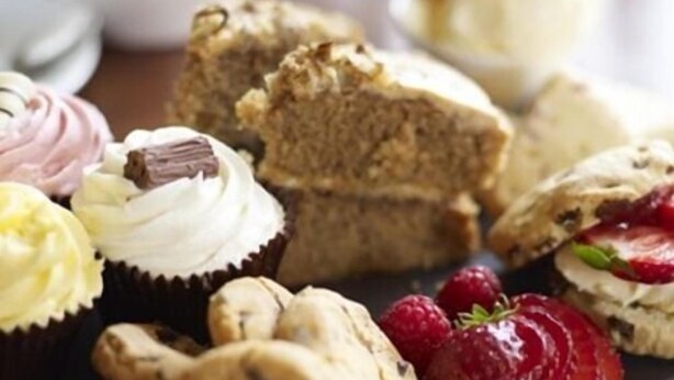 A variety of pastries including cupcakes, muffins, and cookies, along with fresh strawberries. - The Angel Inn (Colchester)