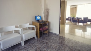 A reception area with a desk, computer, and two white chairs. - Azuline Hotel Mediterraneo (Santa Eulalia del Rio)
