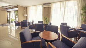 A hotel lobby with seating arrangements, a reception desk, and large windows with curtains. - Azuline Hotel Mediterraneo (Santa Eulalia del Rio)