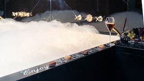 Eine Bar mit einem Weinglas, Eiswürfeln und Snacks.